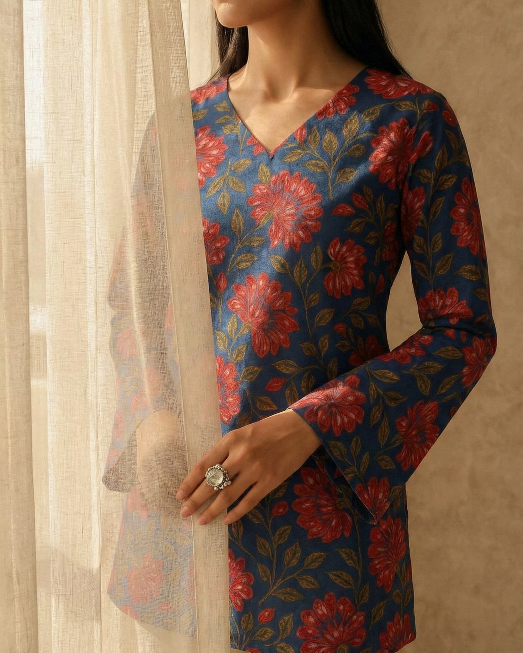 Woman wearing a floral long-sleeve top with a neutral background